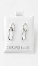 Load image into Gallery viewer, Sterling silver paperclip-shaped drop earrings displayed on a white textured backing card that reads 'STERLING SILVER'.
